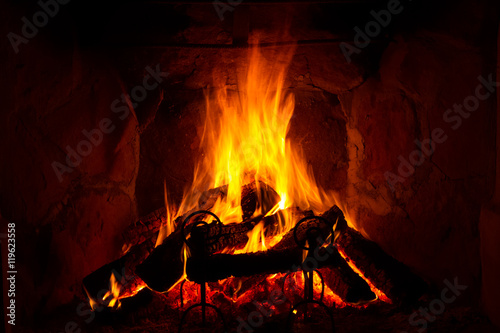 fire burning in a fireplace in a cosy, warm atmosphere, in autumn (fall) or winter
