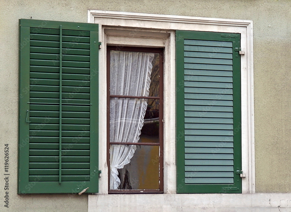 house window with green shutters and lace curtain house window with green shutters and lace curtain