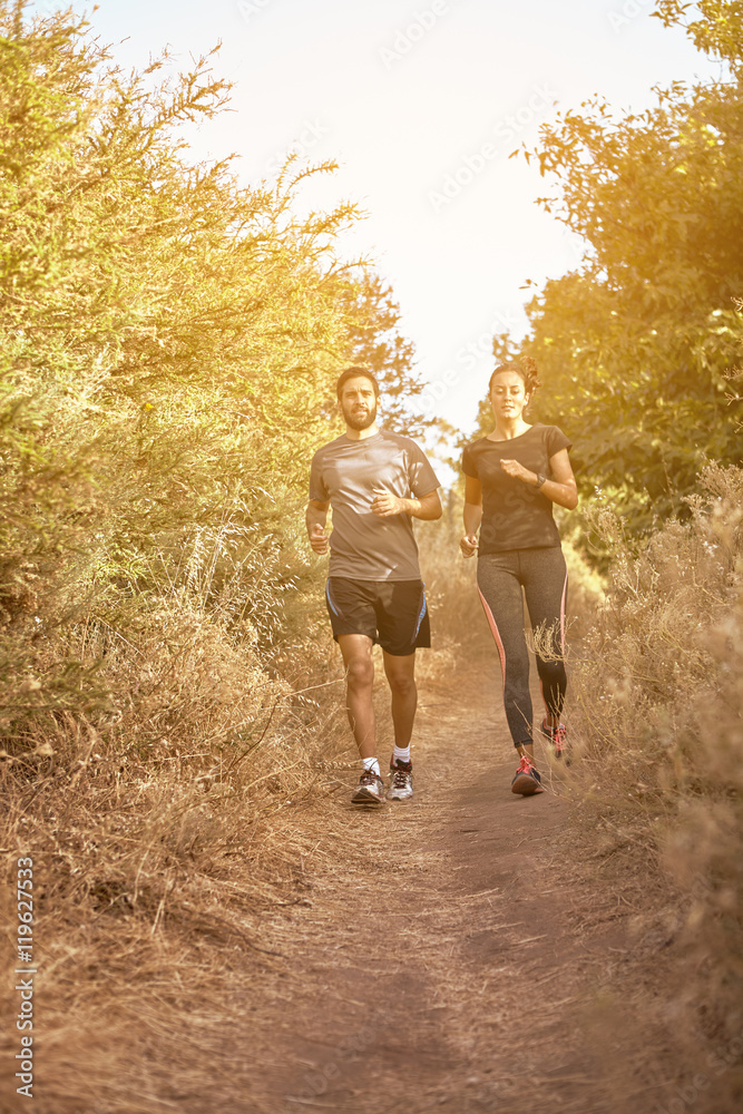 Fototapeta premium Comfortable couple running down a path