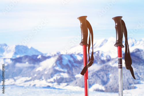 skiing in Alps, close up of two ski poles on mountains background photo
