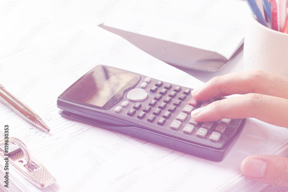 Financial data analyzing. Close-up photo of a businessman's hand counting on calculator in office or home. Soft focus
