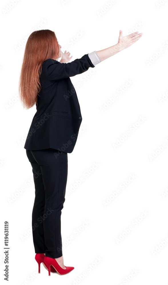 Back view of young redhead business woman pointing at wall. beautiful girl in dark suit. Rear view people collection. backside view of person. Isolated over white background. Back view of young redhead business woman pointing at wall. beautiful girl in dark suit. Rear view people collection. backside view of person. Isolated over white background.