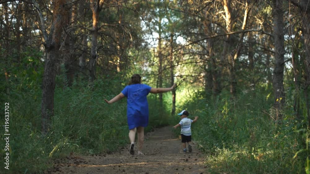 mother and son running in woods mother and son running in woods
