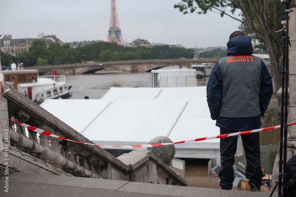 flood in Paris on the Seine river, unidentified security person standing on the stairs of bridge Alexandre III, France, july 2016