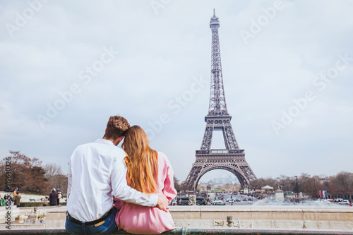 romantic couple looking at Eiffel tower in Paris, honeymoon background