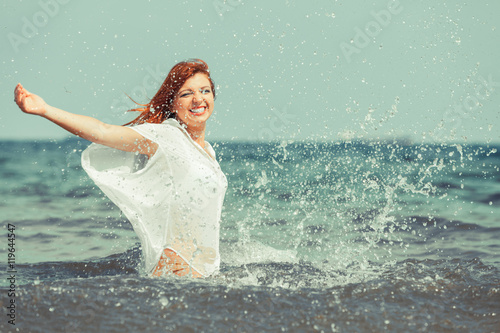 Girl splashing water on the coast.