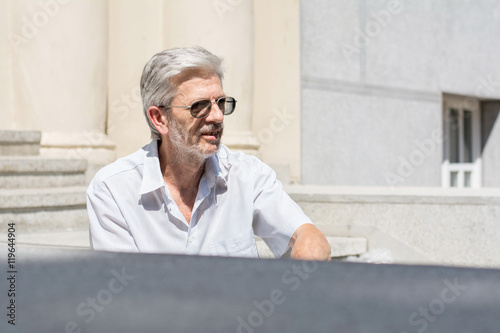 Fashionable senior man sitting on stairs photo