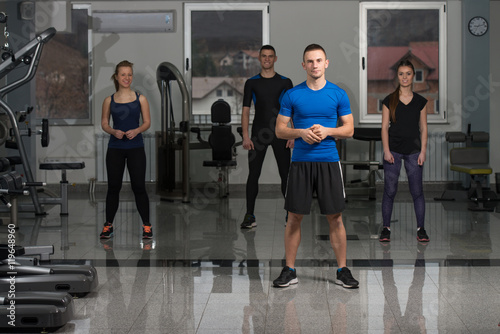 Group Of Smiling People Exercising In The Gym