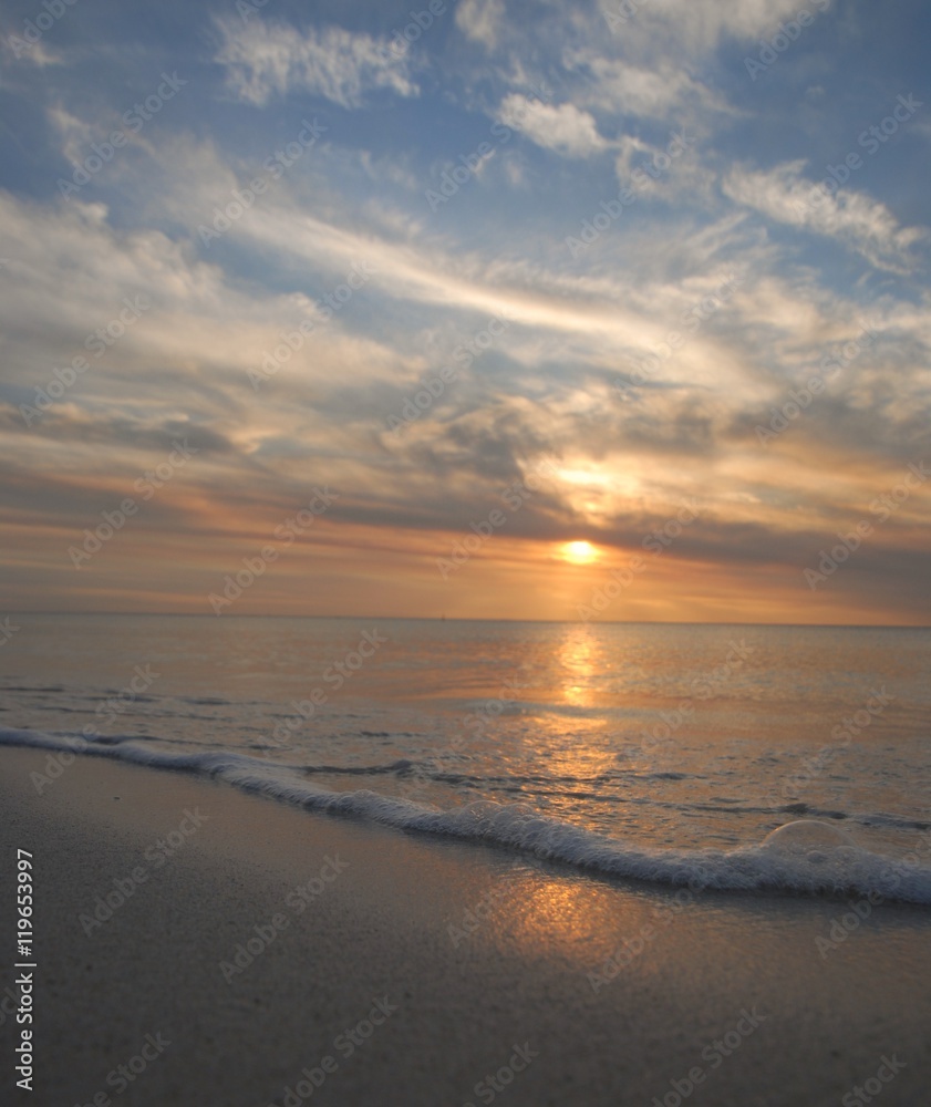 small waves and foam at sunset