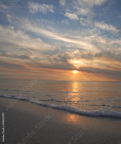 small waves and foam at sunset © gpunler62