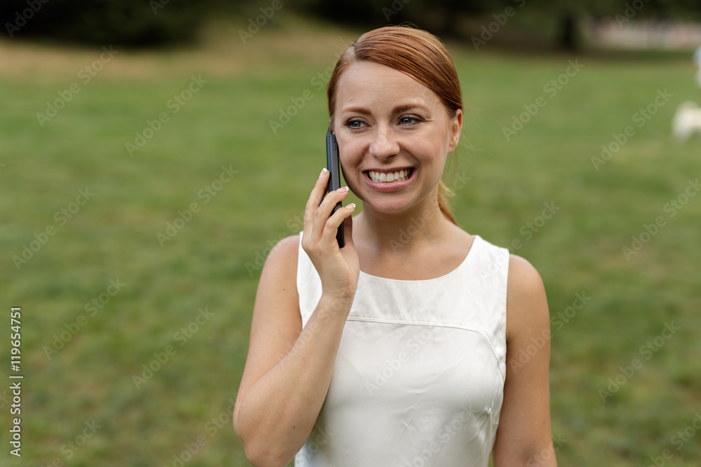 Caucasian woman in city park talking on cell phone Caucasian woman in city park talking on cell phone