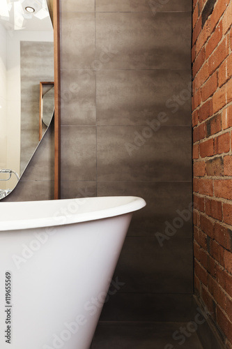 Close up of bath end against grey tiled wall background photo