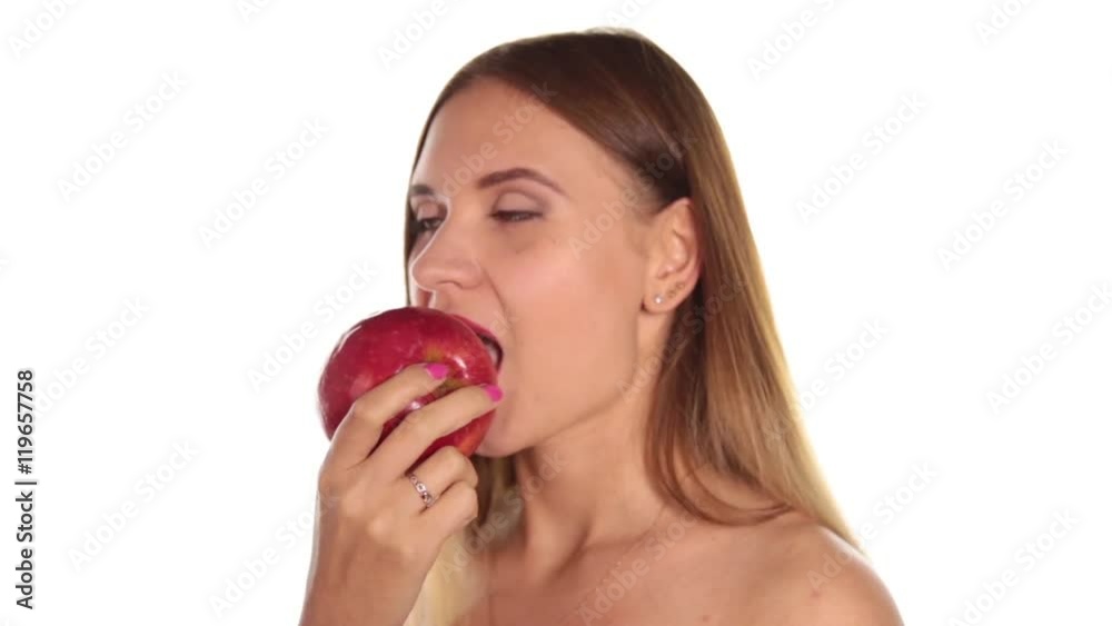 naked young woman wears red lipstick and has her hair down, and brushed, eating a big, dark red apple. healthy food - strong teeth concept. On a white background naked young woman wears red lipstick and has her hair down, and brushed, eating a big, dark red apple. healthy food - strong teeth concept. On a white background