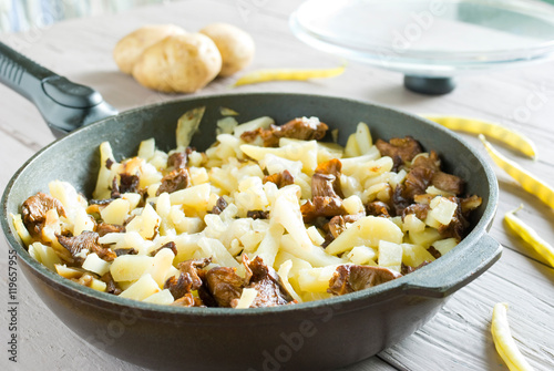 fried potatoes with mushrooms in a frying pan