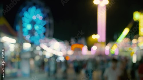 Carnival Background: Out of Focus People Walking and Amusement Rides, Booths, Ferris Wheel