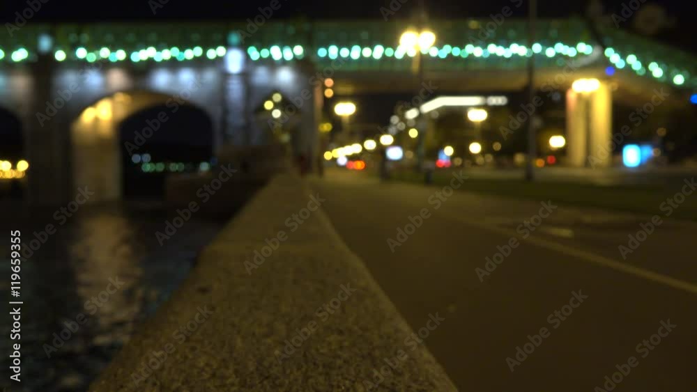 Blurred cyclist on urban embankment at night. 4K bokeh clip Blurred cyclist on urban embankment at night. 4K bokeh clip