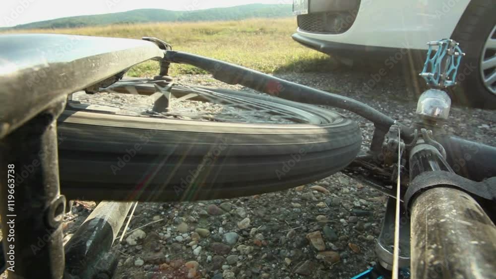 Mountain bicycle rear wheel spinning at grass lawn after fall