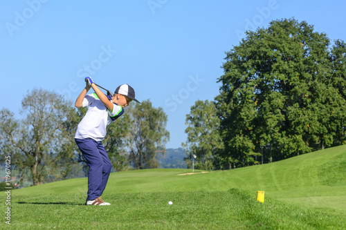 Jugendlicher Golfer beim Abschlag 