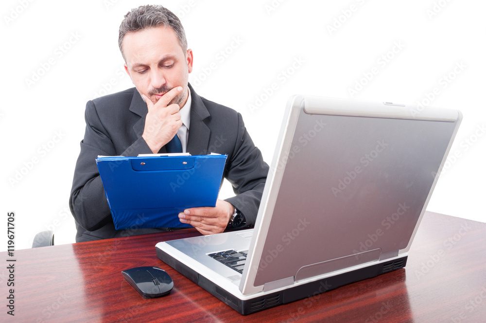 Pensive manager reading something from clipboard Pensive manager reading something from clipboard