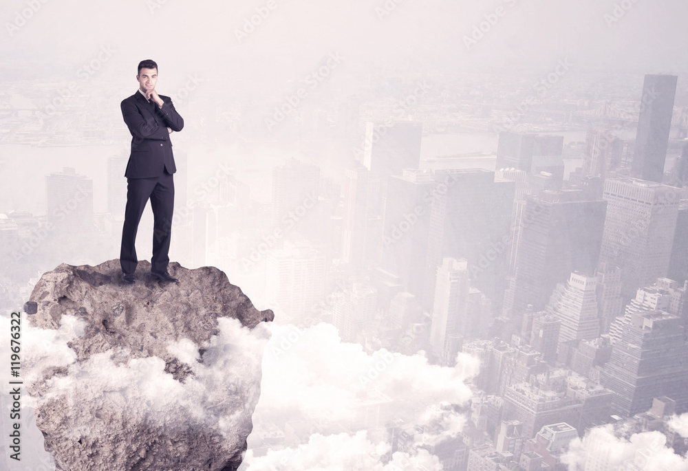 Winner business person standing on rock Winner business person standing on rock