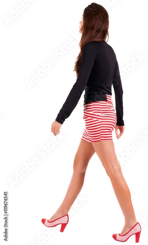 back view of walking woman in red dress. beautiful brunette girl in motion. backside view of person. Rear view people collection. Isolated over white background.