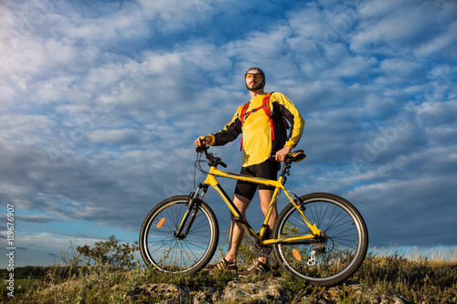 Fototapeta Naklejka Na Ścianę i Meble -  Mountain Bike cyclist riding single track above sunset valley