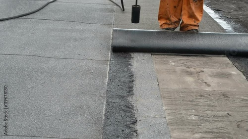 Roofer doing repair waterproofing flat roofs.