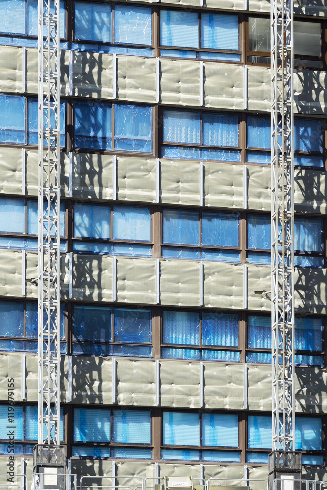 workers installing aluminium composite panels to repair , restore , the facade of building