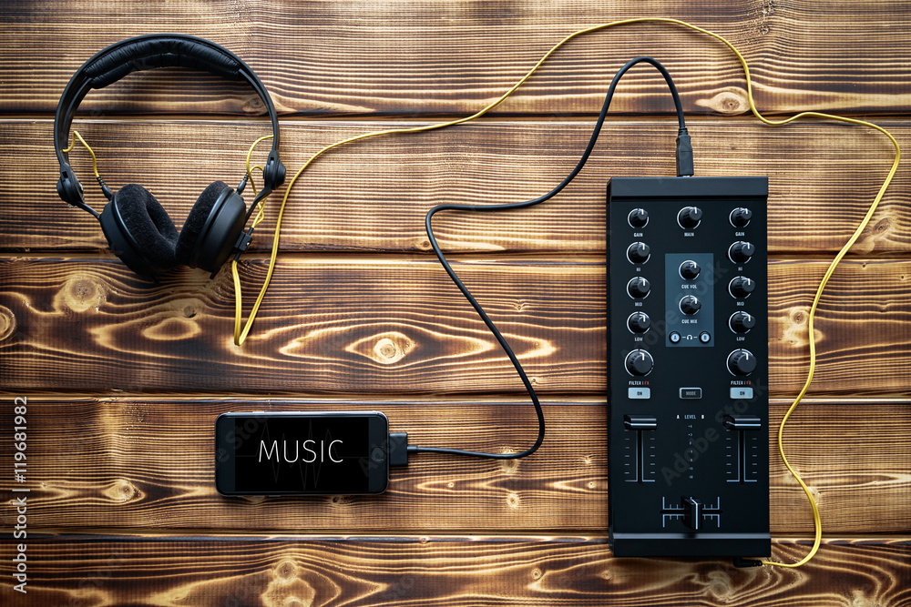 Portable dj music mixer set: headphones, mixer and smartphone connected  together lay on wood background. Stock Photo | Adobe Stock
