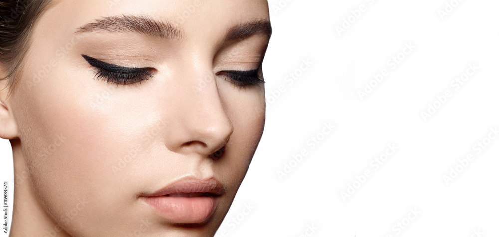 Woman with clean skin with natural make-up and with black arrows on the eyes close up