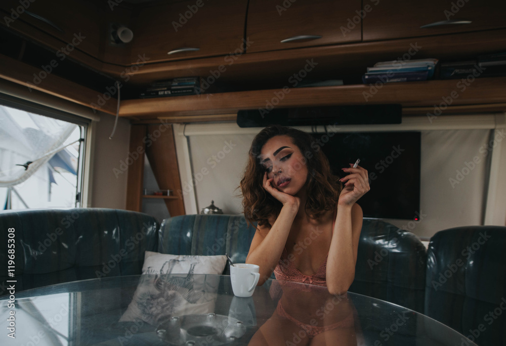 Sexy woman in underwear sitting at the table and smoking Sexy woman in underwear sitting at the table and smoking