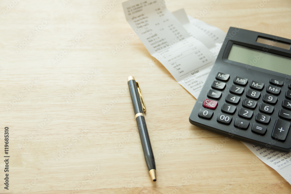 pen, bills under calculator on wood table, natural day light, selective focus, space for copy pen, bills under calculator on wood table, natural day light, selective focus, space for copy