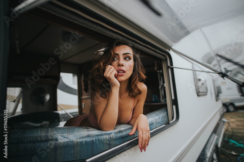 Portrait of young woman in underwear looking at window