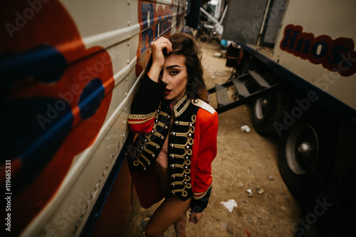 Young woman in red coat and underwear posing between trailers photo