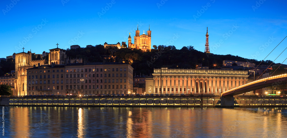 Night view over the Saone river to the courthouse and Fourviere cathedral in Lyon city.