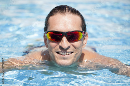Hombre con gafas de sol sonriendo en la piscina © Ricardo Ferrando