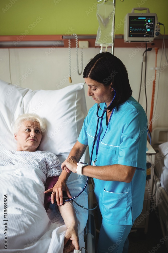 Nurse checking blood pressure of senior patient Nurse checking blood pressure of senior patient