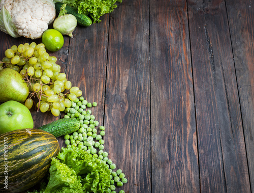 green vegetables and fruits on dark wooden background