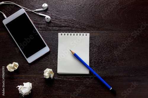 Top view pencil,note paper,white smartphone,black coffee,earphon photo