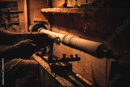 Slika na platnu An artisan carves a piece of wood using a manual lathe