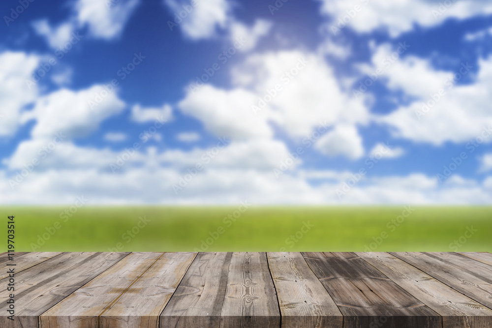 Wood top table on blur blue sky and green prairie background can
