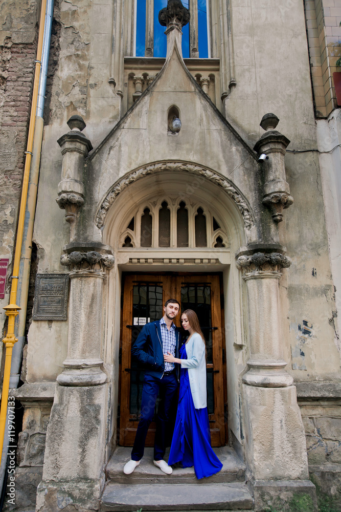 Attractive young people standing together near old doors