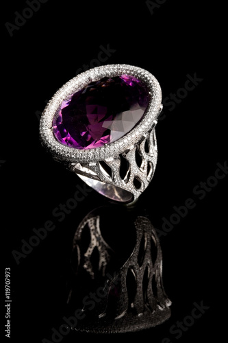 Beautiful ring with purple gem (stone) amethyst isolated on bla