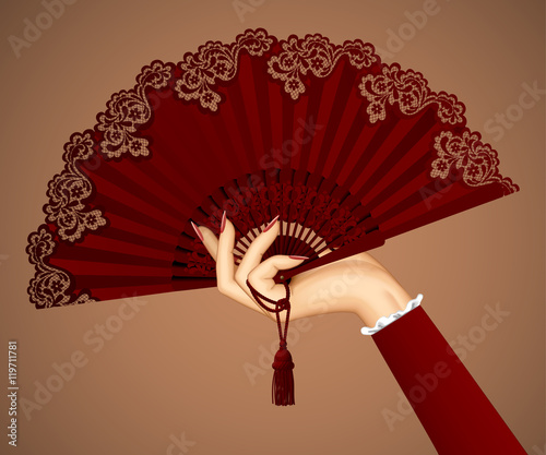 Female hand with open vintage fan isolated in brown colors