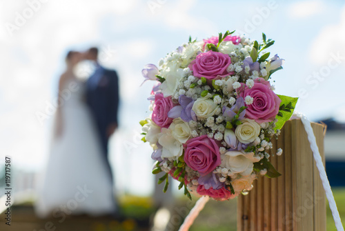 Couple kissing on the background of a wedding bouquet. Blurred s