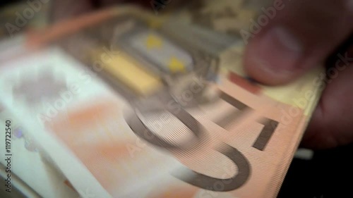 Businessman’s hands counting euro bills in darkness photo
