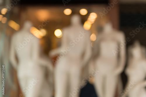 De focused/Blur image of boutique window with dressed mannequins. Boutique display window with mannequins in fashionable dresses. Toned image.