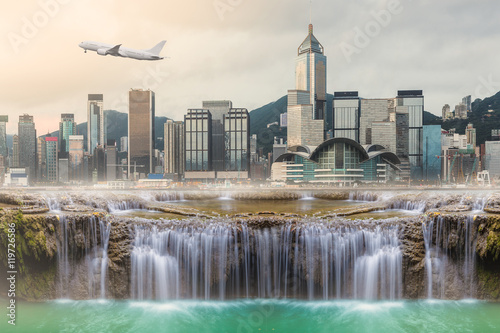 Surreal image of Huge waterfall in middle of urban city ,, capital city , airplane , fog , warm light , Water land , long exposure .