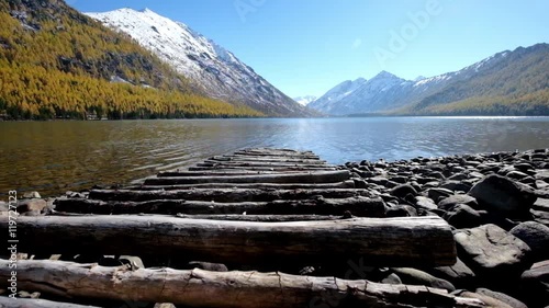 Wooden footbridge pier and mountain autumn landscape on Lower Multinskoe lake in the Altai  at early morning photo