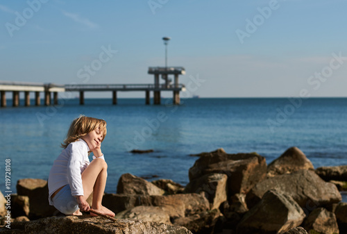 Young boy on sea beach rocks